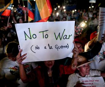 Un partidario del presidente venezolano Nicolás Maduro sostiene un cartel durante una manifestación en favor de la paz en Caracas y en contra del bloqueo militar por parte de EE. UU..