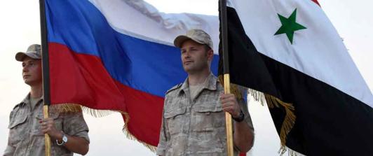 Soldados con la bandera de Siria y Rusia