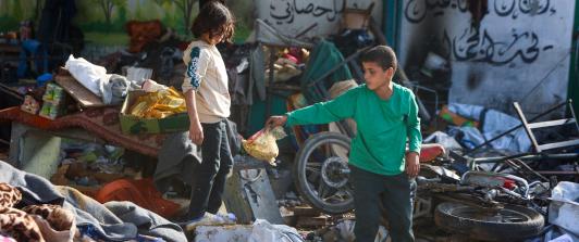 Niños sobre los escombros de la escuela, al verla destruída