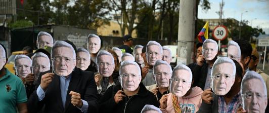 Personas con máscaras de Álvaro Uribe.