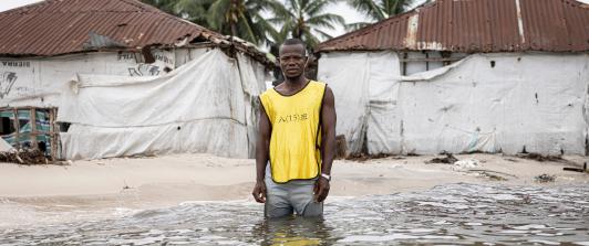 Hassan Kargbo posa para un retrato frente a dos casas durante la marea alta en la isla Nyangai, el 30 de abril de 2025.