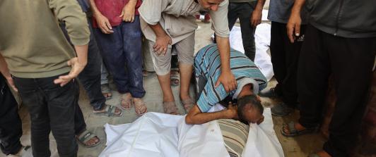 Un palestino llora sobre los cuerpos cubiertos con sábanas de sus familiares, muertos en un ataque israelí contra una panadería improvisada instalada en una tienda de campaña en la calle Al-Nassr, en la ciudad de Gaza.