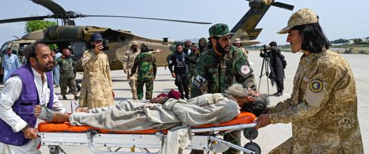 Voluntarios afganos y personal de seguridad talibán transportan a una víctima del terremoto evacuada por un helicóptero militar desde el distrito de Nurgal, en la provincia de Kunar, tras su llegada a Jalalabad para recibir asistencia médica.