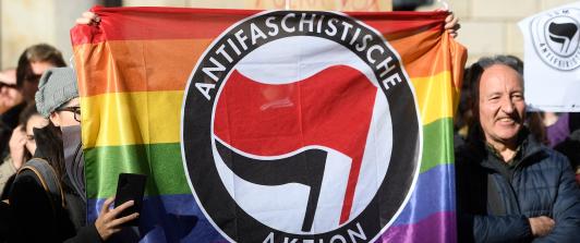 Contramanifestantes sostienen una bandera del partido antifascista Aktion en Barcelona el 12 de enero de 2020 durante una concentración de simpatizantes del partido español de extrema derecha VOX para protestar contra el nuevo gobierno de coalición del presidente del Gobierno español.