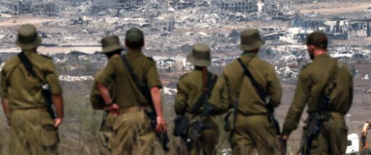 Soldados del ejército israelí observan los edificios destruidos en la Franja de Gaza mientras se encuentran en la frontera con el territorio palestino.