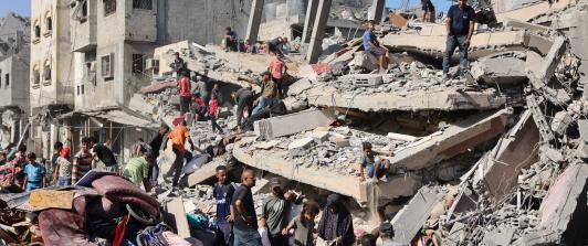 Palestinos inspeccionan un edificio destruido tras el bombardeo nocturno del ejército israelí sobre el campo de refugiados palestinos de Al-Shati, al oeste de la ciudad de Gaza.