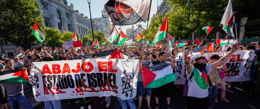 Manifestantes pro palestinos enarbolan banderas y pancartas palestinas tras invadir la calle y obligar a los organizadores de la carrera a suspender la 21.ª y última etapa de la Vuelta a España 2025, una carrera de 101 km entre Alalpardo y Madrid, en Madrid.