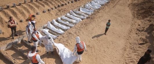 Trabajadores sanitarios y civiles realizan un entierro masivo de palestinos en un cementerio de Jan Yunis, en el sur de la Franja de Gaza.