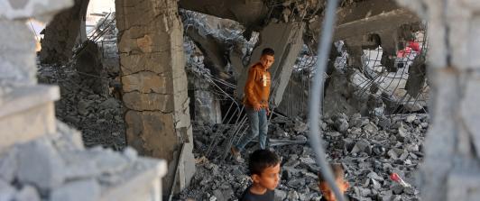 Niños palestinos caminan entre los escombros de un edificio dañado perteneciente al Ministerio de Dotaciones Religiosas, que albergaba a personas desplazadas en el barrio de Zeitoun, en la ciudad de Gaza. 
