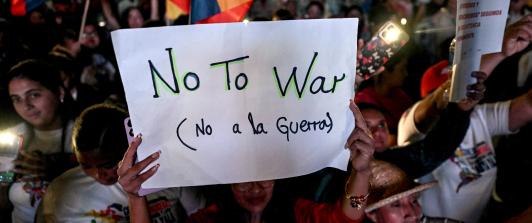 Un partidario del presidente venezolano Nicolás Maduro sostiene un cartel durante una manifestación en favor de la paz en Caracas y en contra del bloqueo militar por parte de EE. UU..