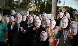 Personas con máscaras de Álvaro Uribe.