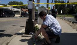 Persona dejando florez en el lugar del tiroteo en minneapolis