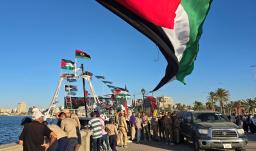 Personas posan para una foto frente al barco Omar al-Mukhtar, un barco libio que zarpó el 17 de septiembre para unirse a la Flotilla Global Sumud, en el puerto de Trípoli. 