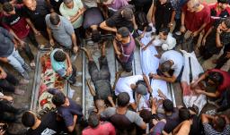 La gente rodea los cadáveres de palestinos, algunos muertos en los ataques israelíes de madrugada y otros asesinados el día anterior mientras buscaban ayuda humanitaria cerca de Zikim, al oeste de Beit Lahia, en el patio del hospital al-Shifa de la ciudad de Gaza.