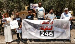 Periodistas árabe-israelíes levantan pancartas y una bandera palestina durante una manifestación en solidaridad con sus compañeros de profesión fallecidos en los ataques israelíes en la Franja de Gaza, en la ciudad norteña de Nazaret, el