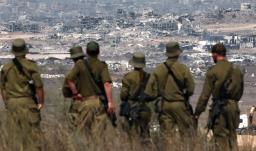 Soldados del ejército israelí observan los edificios destruidos en la Franja de Gaza mientras se encuentran en la frontera con el territorio palestino.
