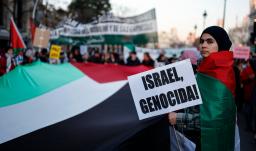 Una mujer sostiene un cartel con el lema «¡Israel, genocidio!» durante una manifestación en apoyo al pueblo palestino y para exigir el fin de la guerra en Gaza, celebrada en Madrid.