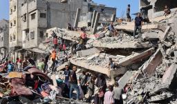 Palestinos inspeccionan un edificio destruido tras el bombardeo nocturno del ejército israelí sobre el campo de refugiados palestinos de Al-Shati, al oeste de la ciudad de Gaza.