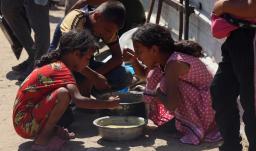 En un comedor social de Jan Yunis, en el sur de la Franja de Gaza, se reparten raciones de comida caliente entre los niños palestinos. Mientras esperan su turno, algunos comen arroz cocido.