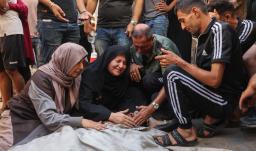 Los palestinos lloran junto al cadáver de un familiar asesinado en los ataques israelíes contra la ciudad de Gaza al amanecer, en el hospital Al-Shifa. 