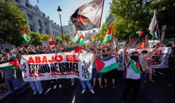 Manifestantes pro palestinos enarbolan banderas y pancartas palestinas tras invadir la calle y obligar a los organizadores de la carrera a suspender la 21.ª y última etapa de la Vuelta a España 2025, una carrera de 101 km entre Alalpardo y Madrid, en Madrid.