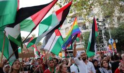Manifestantes hacen gestos y ondean banderas palestinas durante una concentración convocada por la «Comunitat Palestina de Catalunya» (Comunidad Palestina de Cataluña) en solidaridad con los palestinos, frente al edificio «Casa Milà» del arquitecto español Antonio Gaudí, conocido popularmente como «La Pedrera», en Barcelona.