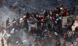 Los palestinos se apresuran a recibir paquetes de alimentos después de que los camiones de ayuda entraran por el paso fronterizo de Karem Abu Salem, en Jan Yunis, al sur de la Franja de Gaza.