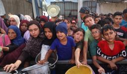 Niños palestinos se reúnen para recibir raciones de comida de un comedor benéfico en Nuseirat, en la Franja de Gaza central.