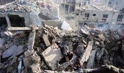 Palestinos intentan recuperar un cadáver de entre los escombros de una casa destruida en un ataque israelí durante la noche, en la ciudad de Gaza.