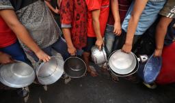 Niños palestinos hacen cola frente a un comedor social en el campo de refugiados de Nuseirat, en el centro de la Franja de Gaza. 