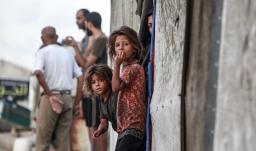 Niñas palestinas desplazadas junto a la entrada de una tienda utilizada como refugio temporal en Deir el-Balah, en la Franja de Gaza central.