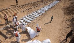 Trabajadores sanitarios y civiles realizan un entierro masivo de palestinos en un cementerio de Jan Yunis, en el sur de la Franja de Gaza.