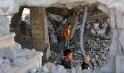 Niños palestinos caminan entre los escombros de un edificio dañado perteneciente al Ministerio de Dotaciones Religiosas, que albergaba a personas desplazadas en el barrio de Zeitoun, en la ciudad de Gaza. 