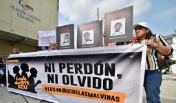 Familiares y miembros de organizaciones de derechos humanos sostienen fotografías y una pancarta con el lema «Ni perdón ni olvido» frente a un tribunal de Guayaquil, Ecuador, tras la condena de los 11 militares por desaparición forzada. 