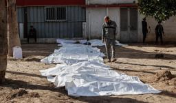 Un hombre observa las bolsas con restos humanos tras la exhumación de las tumbas por parte de la defensa civil en el interior del Hospital Bautista Árabe Al-Ahli para trasladar los restos a los cementerios oficiales de la ciudad de Gaza. 