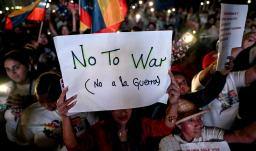 Un partidario del presidente venezolano Nicolás Maduro sostiene un cartel durante una manifestación en favor de la paz en Caracas y en contra del bloqueo militar por parte de EE. UU..