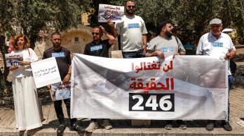 Periodistas árabe-israelíes levantan pancartas y una bandera palestina durante una manifestación en solidaridad con sus compañeros de profesión fallecidos en los ataques israelíes en la Franja de Gaza, en la ciudad norteña de Nazaret, el