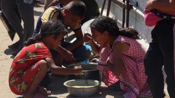 En un comedor social de Jan Yunis, en el sur de la Franja de Gaza, se reparten raciones de comida caliente entre los niños palestinos. Mientras esperan su turno, algunos comen arroz cocido.