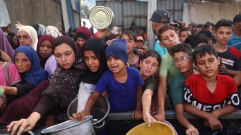 Niños palestinos se reúnen para recibir raciones de comida de un comedor benéfico en Nuseirat, en la Franja de Gaza central.