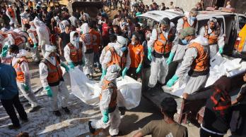 Miembros de Defensa Civil descargan bolsas con los restos mortales de los miembros de la familia Shahebar, que fueron enterrados en tumbas temporales, mientras son trasladados al cementerio Sheikh Shaaban, en la ciudad de Gaza, el 24 de octubre.