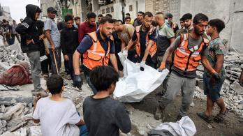 Palestinos transportan un cadáver que recuperaron de los escombros de una casa destruida en un ataque israelí perpetrado durante la noche en la ciudad de Gaza.