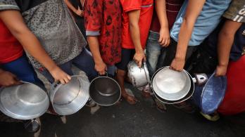 Niños palestinos hacen cola frente a un comedor social en el campo de refugiados de Nuseirat, en el centro de la Franja de Gaza. 