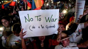 Un partidario del presidente venezolano Nicolás Maduro sostiene un cartel durante una manifestación en favor de la paz en Caracas y en contra del bloqueo militar por parte de EE. UU..
