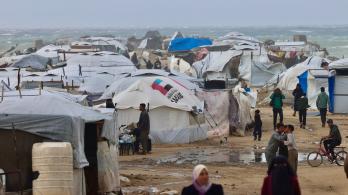 Los desplazados palestinos caminan cerca de tiendas de campaña y refugios improvisados mientras la región sufre las frías condiciones invernales en el campo de refugiados de Al-Mawasi, en el sur de la Franja de Gaza. 