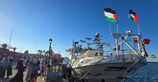 Personas posan para una foto frente al barco Omar al-Mukhtar, un barco libio que zarpó el 17 de septiembre para unirse a la Flotilla Global Sumud, en el puerto de Trípoli.