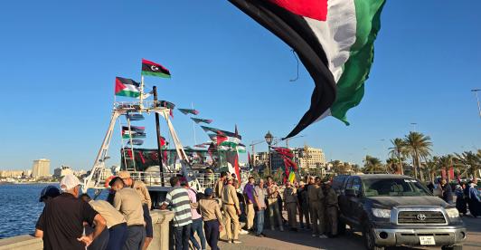 Personas posan para una foto frente al barco Omar al-Mukhtar, un barco libio que zarpó el 17 de septiembre para unirse a la Flotilla Global Sumud, en el puerto de Trípoli. 