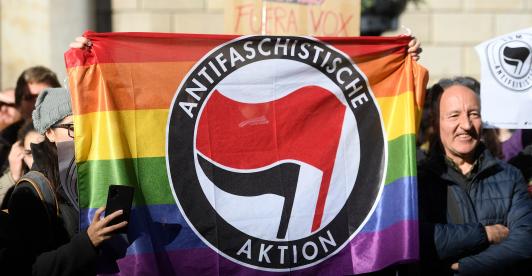 Contramanifestantes sostienen una bandera del partido antifascista Aktion en Barcelona el 12 de enero de 2020 durante una concentración de simpatizantes del partido español de extrema derecha VOX para protestar contra el nuevo gobierno de coalición del presidente del Gobierno español.