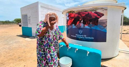 Mujer de la comunidad de Manaure utilizando el sistema de agua potable entregado por el Ministerio de Vivienda