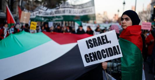 Una mujer sostiene un cartel con el lema «¡Israel, genocidio!» durante una manifestación en apoyo al pueblo palestino y para exigir el fin de la guerra en Gaza, celebrada en Madrid.