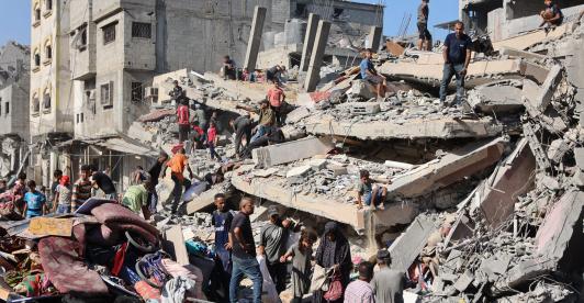 Palestinos inspeccionan un edificio destruido tras el bombardeo nocturno del ejército israelí sobre el campo de refugiados palestinos de Al-Shati, al oeste de la ciudad de Gaza.